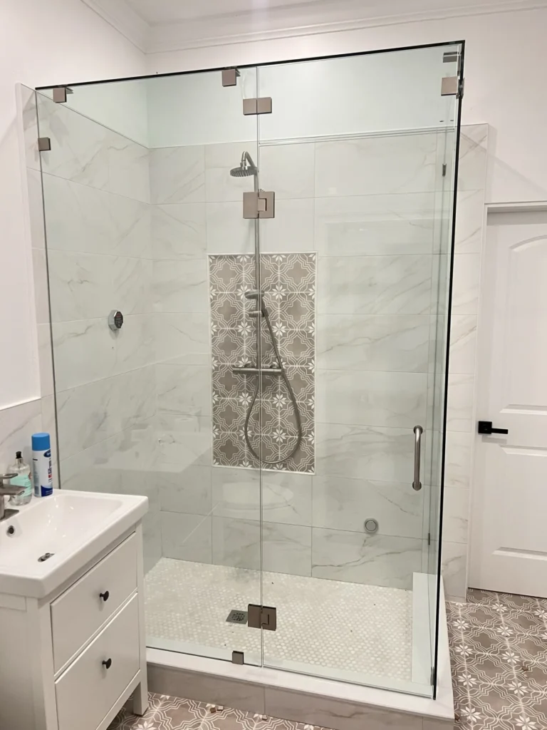 Completed master bathroom renovation with frameless glass shower enclosure, marble-look tile walls and patterned cement tile floor, Tampa Bay FL — Power Contractor Group