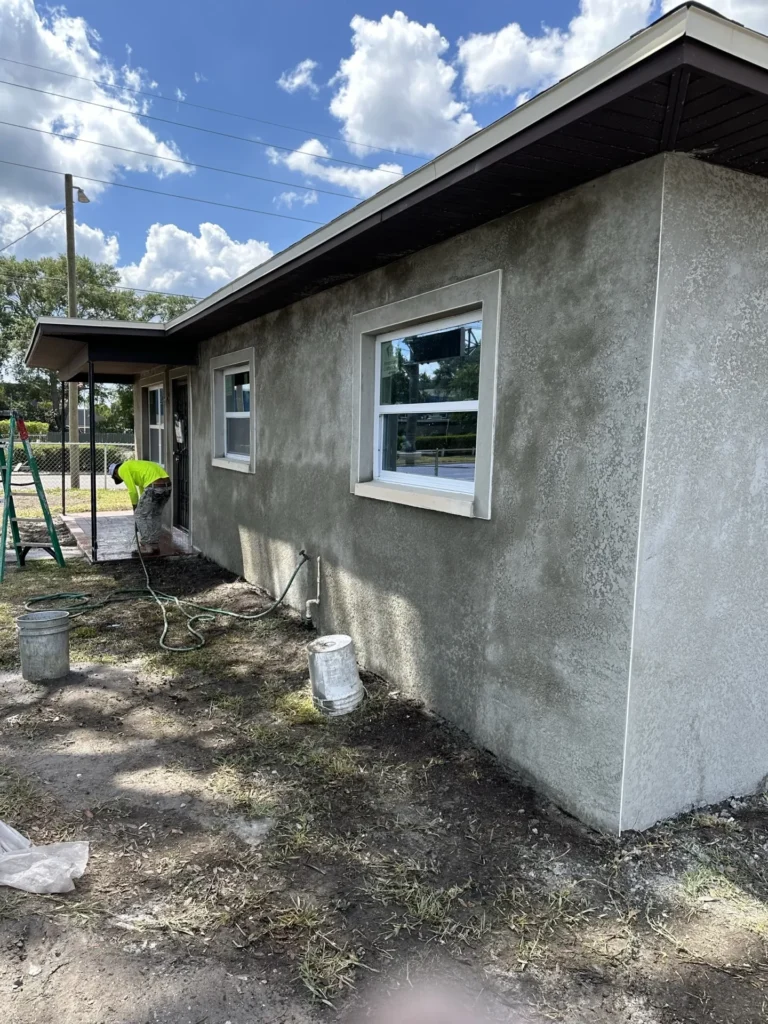New room addition under construction showing stucco-coated concrete block walls with window installation, Tampa Bay FL — Power Contractor Group