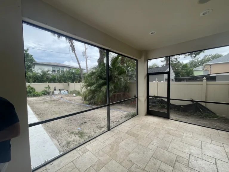 Newly constructed Florida room screen enclosure interior with travertine tile floor and outdoor view, Tampa Bay FL — Power Contractor Group