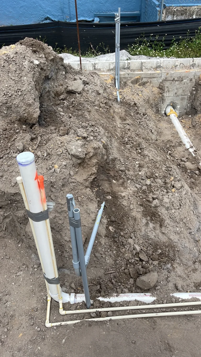 Underground PVC plumbing lines and clean-outs installed in open trench at residential new construction site, Tampa Bay FL — Power Contractor Group